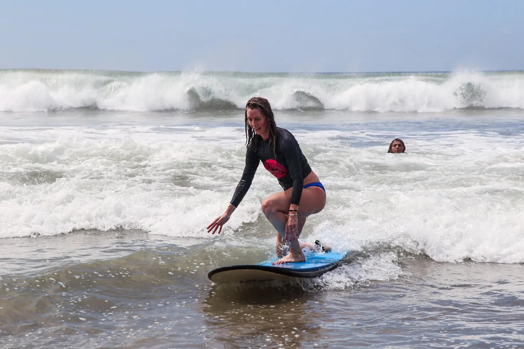 Adult beginner riding a small wave during surf lessons in Santa Teresa Costa Rica