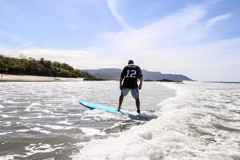 Adult beginner surfing in Santa Teresa Costa Rica during a real lesson at Zeneidas Surf Garden