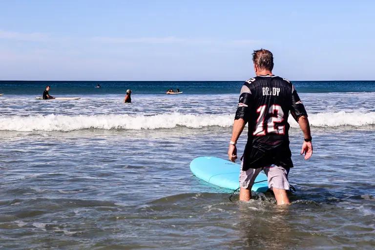 Adult beginner surfer smiling in the water after catching waves in Santa Teresa